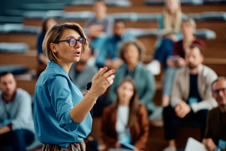 A woman address a crowd with determination